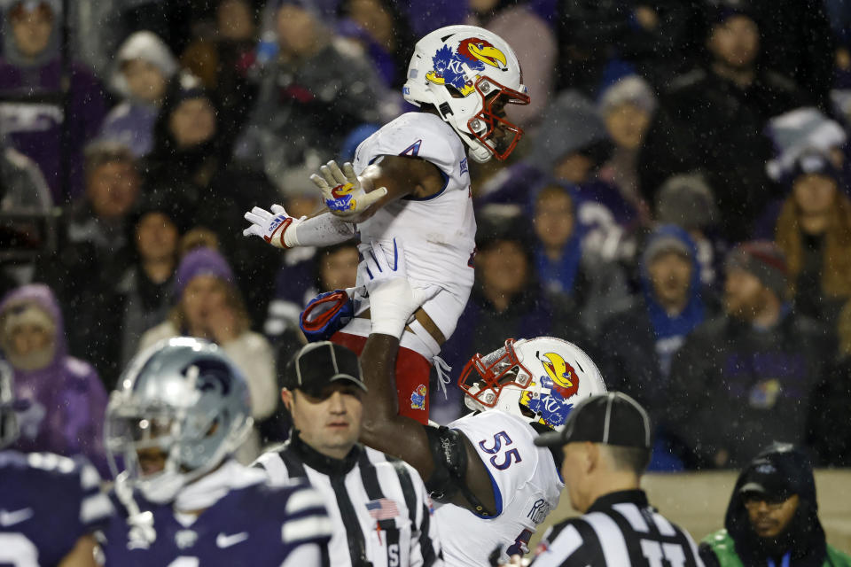 Kansas running back Devin Neal (4) celebrates his touchdown with offensive lineman Ar'maj Reed-Adams (55) during the second quarter of the team's NCAA college football game against Kansas State on Saturday, Nov. 26, 2022, in Manhattan, Kan. (AP Photo/Colin E. Braley)