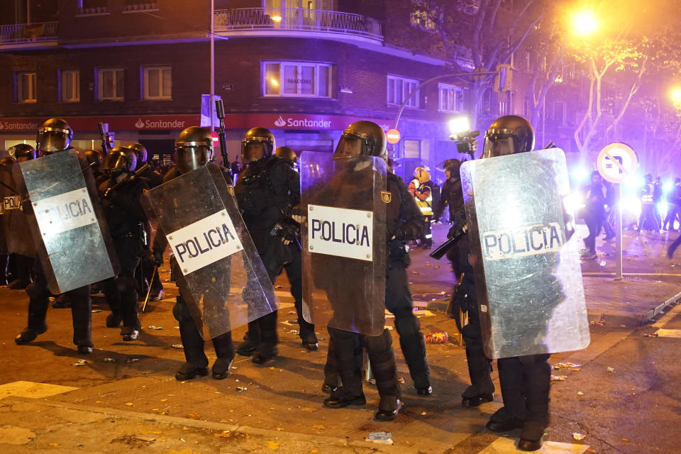 Riot police try to disperse demonstrators during a protest against the amnesty at the headquarters of Socialist party in Madrid, Spain, Thursday, Nov. 16, 2023. Spain's acting Socialist prime minister, Pedro Sánchez, has been chosen by a majority of legislators to form a new leftist coalition government in a parliamentary vote. The vote came after nearly two days of debate among party leaders that centered almost entirely on a highly controversial amnesty deal for Catalonia's separatists that Sánchez agreed to in return for vital support to get elected prime minister again. (AP Photo/Andrea Comas)