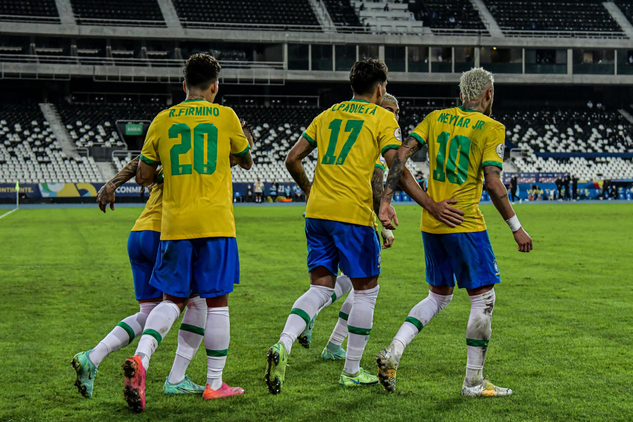 Jugadores de la selección de fútbol de Brasil, de espaldas, celebrando un gol