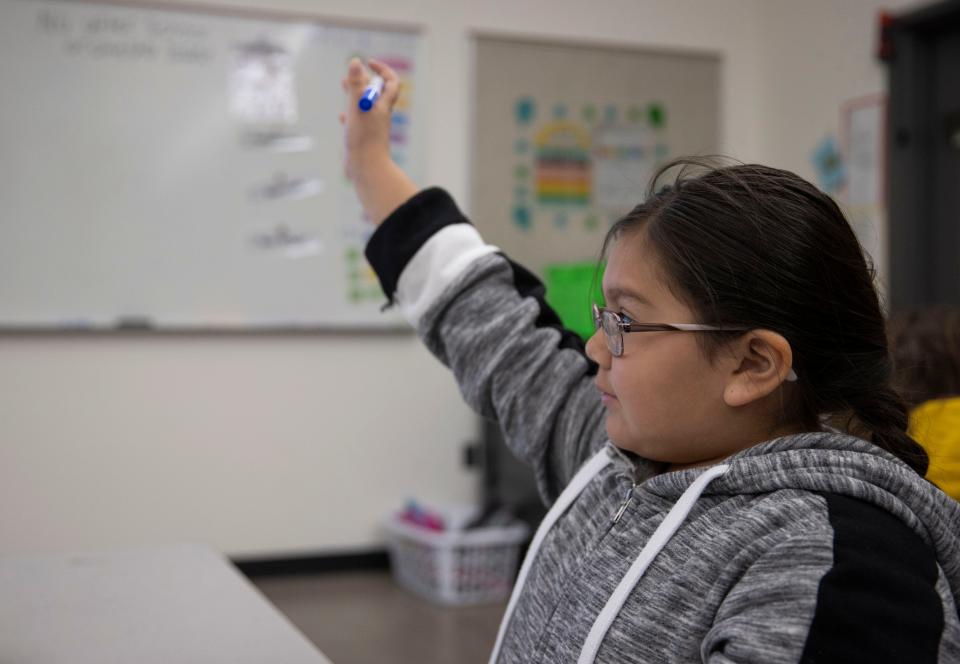 Mikailyn Parish, 10, raises her hand to answer a question during a reading skills lesson in Angela Mosca's class at Mary Eyre Elementary School in Salem, Ore., on Tuesday, April 26, 2022.