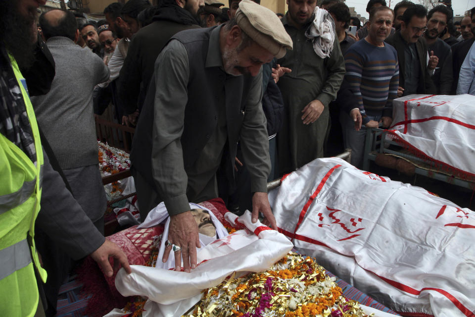 People attend the funeral prayers for the victims of Friday's suicide bombing in Peshawar, Pakistan, Saturday, March 5, 2022. The Islamic State says a lone Afghan suicide bomber struck inside a Shiite Muslim mosque in Pakistan's northwestern city of Peshawar during Friday prayers, killing dozens worshippers and wounding more than 190 people. (AP Photo/Muhammas Sajjad)