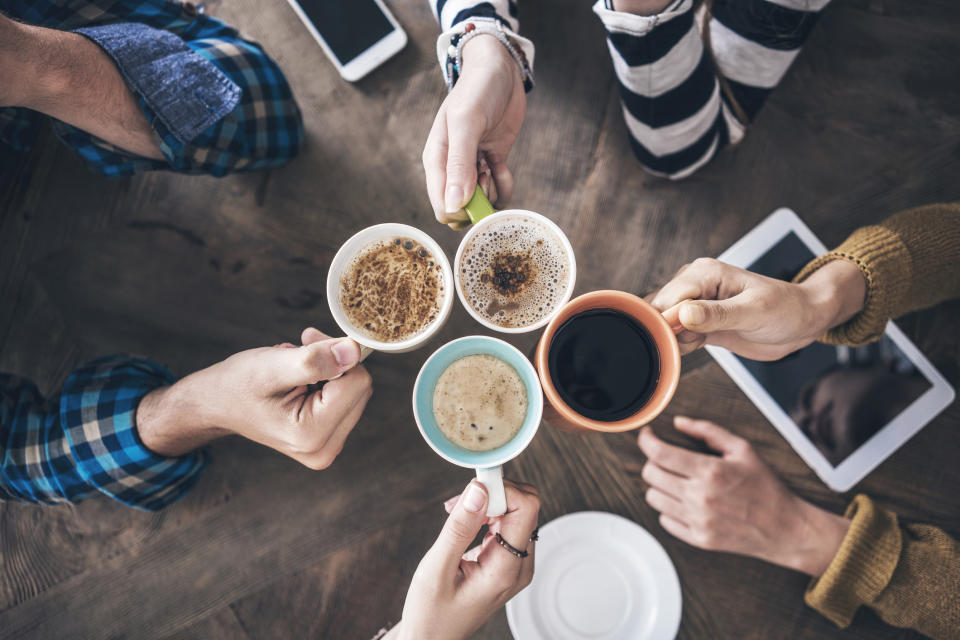 A top-down view of four people drinking coffee.