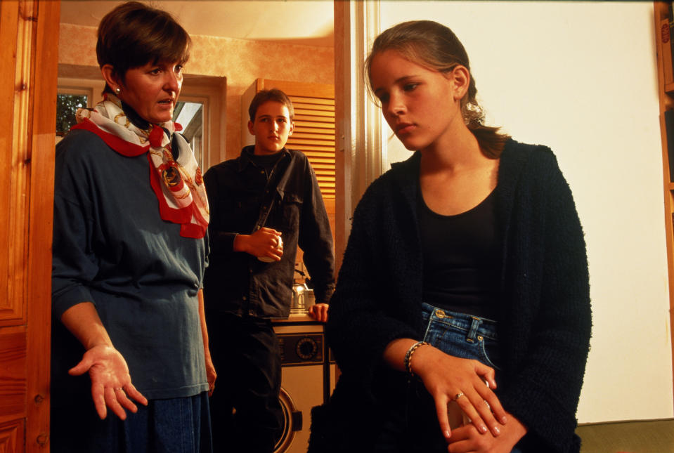 A young girl looking away as she's scolded by her mother