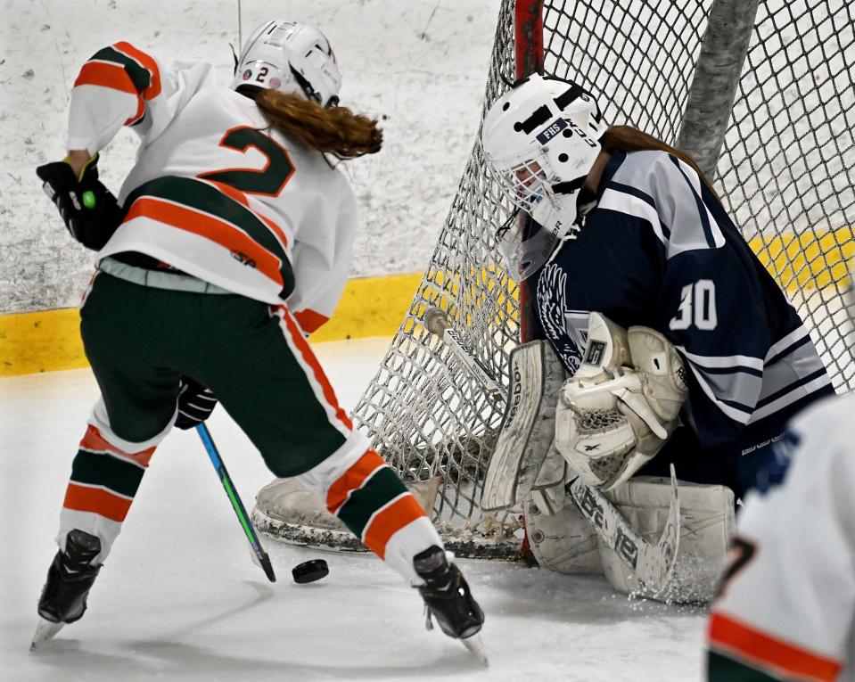 Hopkinton/Dover-Sherborn's Kelly Bailey, left,  maneuvers the puck as Framingham goalie Mikal Franklin blocks the net during the first period  New England Sports Center in Marlborough, Jan. 15, 2021. 