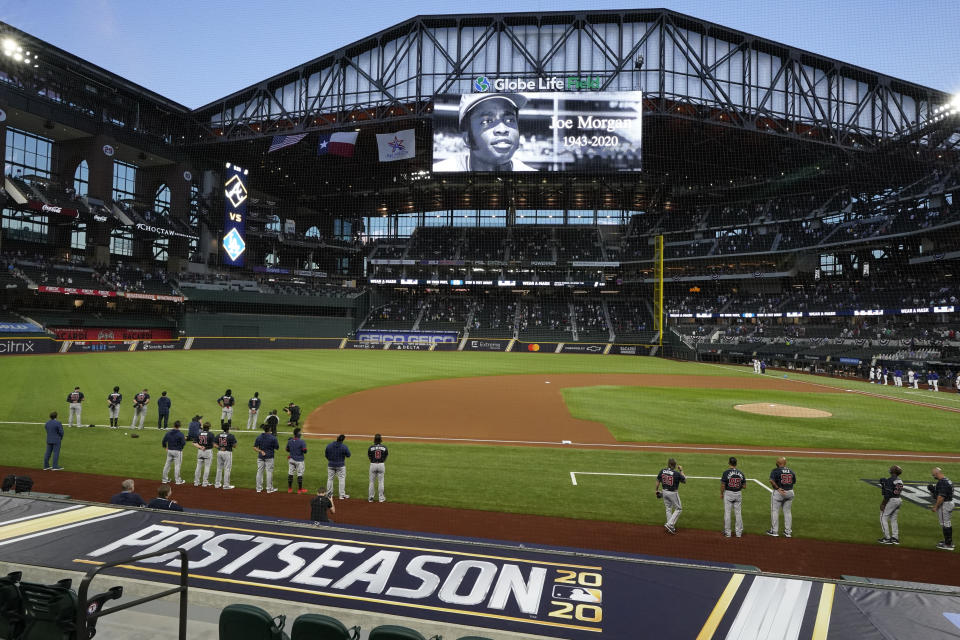 The Atlanta Braves and the Los Angeles Dodgers stand during a moment of silence for Hall of Fame player Joe Morgan, who died Sunday, before Game 1 of a baseball National League Championship Series Monday, Oct. 12, 2020, in Arlington, Texas. (AP Photo/Tony Gutierrez)