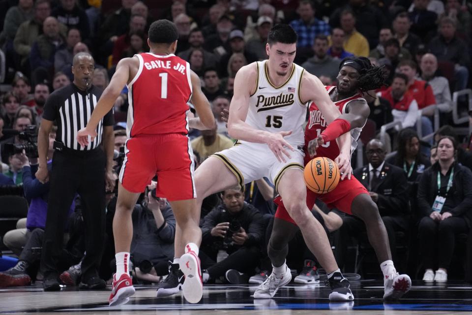 Purdue's Zach Edey (15) is fouled by Ohio State's Isaac Likekele (13) during the first half of an NCAA semifinal basketball game at the Big Ten men's tournament, Saturday, March 11, 2023, in Chicago. (AP Photo/Charles Rex Arbogast)
