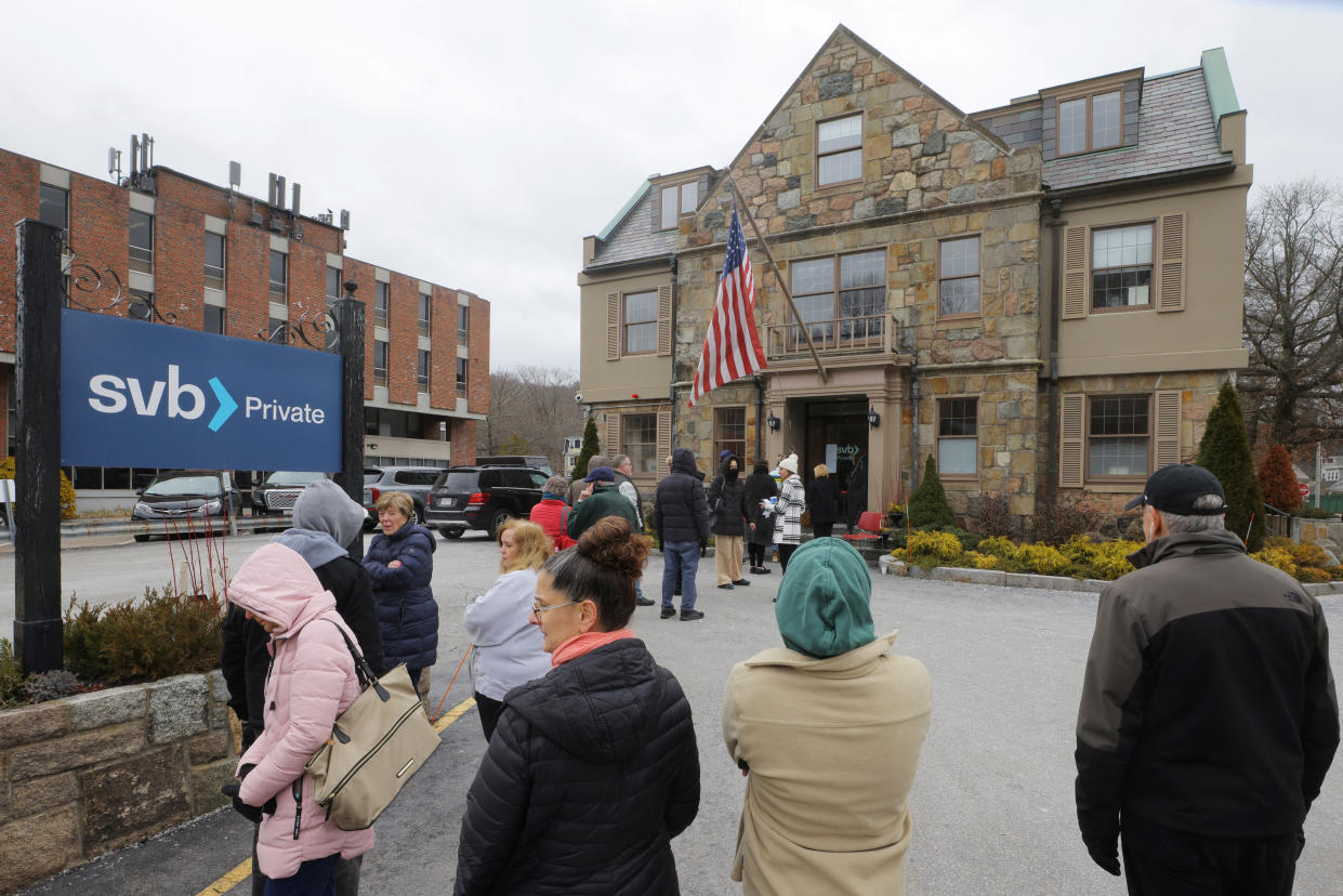 Customers wait in line outside a branch of the Silicon Valley Bank in Wellesley, Massachusetts, U.S., March 13, 2023.     REUTERS/Brian Snyder