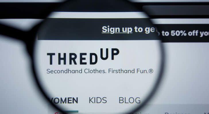 A magnifying glass zooms in on the website for ThredUp (TDUP).