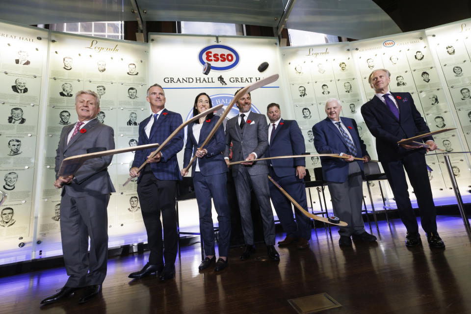 Hockey Hall of Fame 2023 inductees pose during ceremonies Friday, Nov. 10, 2023, in Toronto. From left are Mike Vernon, Pierre Turgeon, Caroline Ouellette, Henrik Lundqvist, Eric Lacroix (son of inductee Pierre Lacroix), Ken Hitchcock, and Tom Barrasso. (Cole Burston/The Canadian Press via AP)