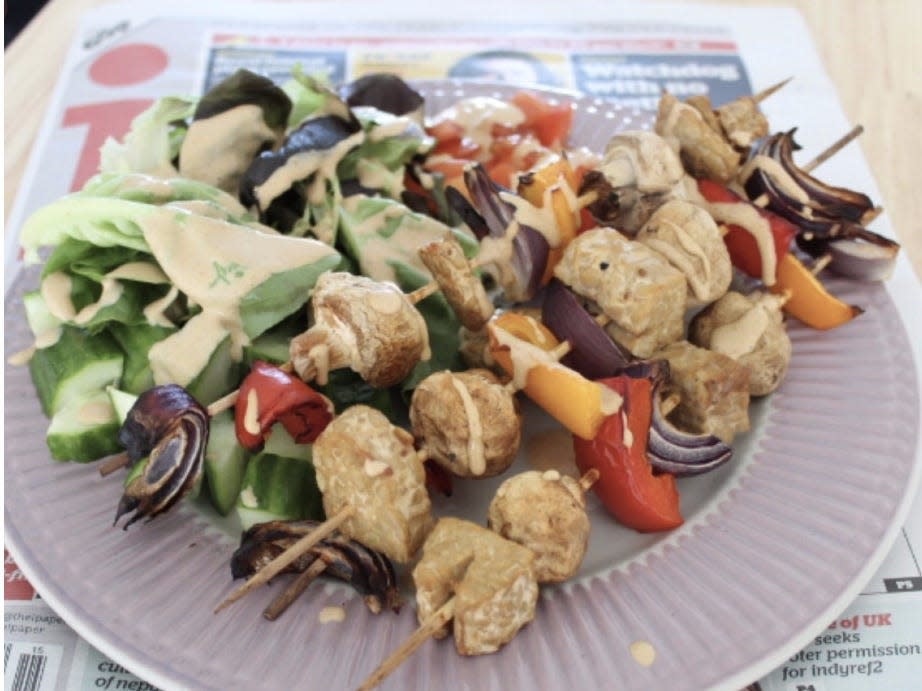 A plant-based, low carb meal featuring kabobs with veggies and salad with dressing