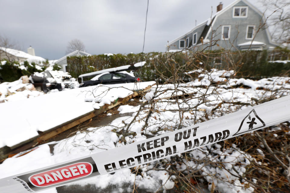 A down utility poll rests on top of a vehicle as snow covered debris from Superstorm Sandy lay in the middle of a street following a nor'easter storm, Thursday, Nov. 8, 2012, in Point Pleasant, N.J. The New York-New Jersey region woke up to wet snow and more power outages Thursday after the nor'easter pushed back efforts to recover from Superstorm Sandy, that left millions powerless and dozens dead last week. (AP Photo/Julio Cortez)