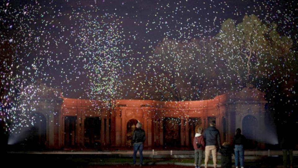 photo of people standing in front of museum looking at firefly like fireworks spark bilbao organic fireworks