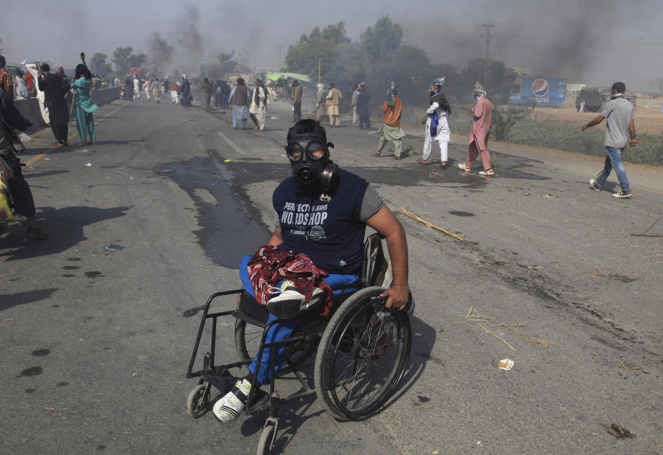 Supporters of Tehreek-e-Labiak Pakistan, a radical Islamist party, take part in a protest march toward Islamabad, on a highway in the town of Sadhuke, in eastern Pakistan, Wednesday, Oct. 27, 2021. Violence at the anti-France Islamist rally in Sadhuke left at least one police officer and two demonstrators dead. ​They demanded the expulsion of France's envoy to Pakistan over publication of caricatures of Islam's Prophet Muhammad in France. (AP Photo/K.M. Chaudary)