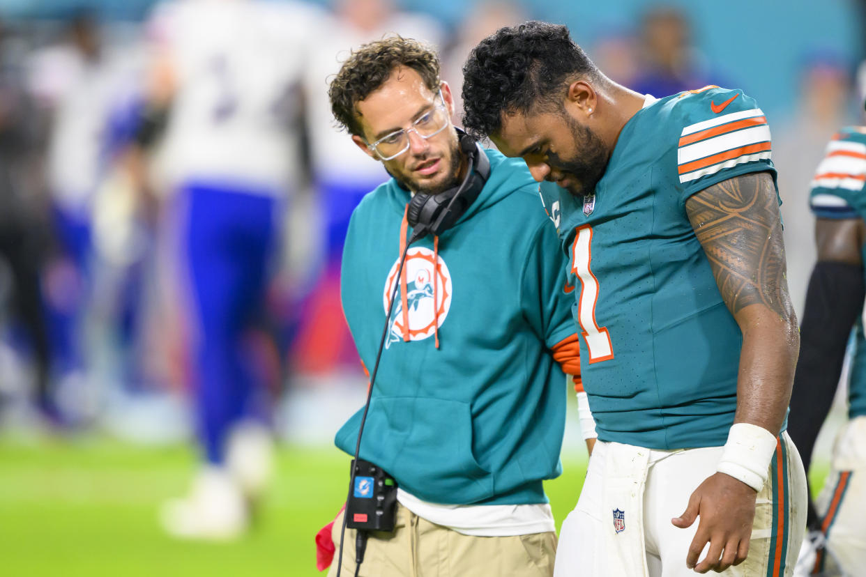 Tua Tagovailoa walks off of the field with Dolphins head coach Mike McDaniel after suffering a concussion Thursday night. (AP Photo/Doug Murray)