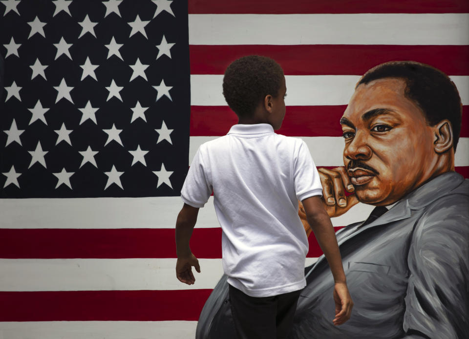 A young boy walks past a painting depicting Dr. Martin Luther King Jr. during a Juneteenth celebration in Los Angeles. Friday, June 19, 2020. Juneteenth marks the day in 1865 when federal troops arrived in Galveston, Texas, to take control of the state and ensure all enslaved people be freed, more than two years after the Emancipation Proclamation. (AP Photo/Jae C. Hong)
