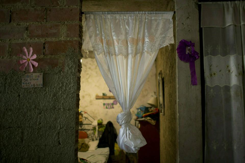 In this Tuesday, Feb. 19, 2019 photo, a curtain hangs in the doorway of what was the bedroom of Jhonny Godoy in La Vega slum of Caracas, Venezuela. According to his family, two days after proclaiming his opposition to President Nicolas Maduro on Twitter, rifle-wielding special police agents wearing black masks stormed into their home, pulled him outside and shot the 29-year-old to death. (AP Photo/Ariana Cubillos)