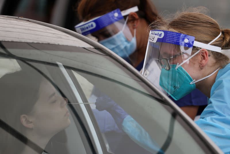 A medical worker administers a test at a drive-through COVID-19 testing centre in Sydney