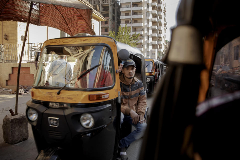 In this Nov. 19, 2019 photo, tuk-tuk drivers make their way with passengers on a street in Cairo, Egypt. Motorized rickshaws known as tuk-tuks have ruled the streets of Cairo’s slums for the past two decades hauling millions of Egyptians home every day. Now the government is taking its most ambitious stand yet against the polluting three-wheeled vehicles: to modernize the neglected transport system, it plans to replace tuk-tuks with clean-running minivans. (AP Photo/Nariman El-Mofty)