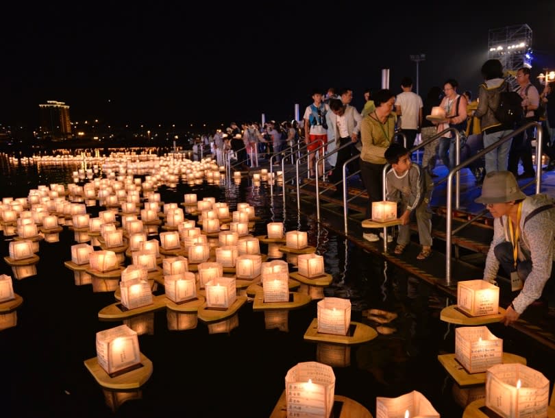 參加者將祈願或追思寫在真如水燈上，然後施放到水面(台灣)。 圖片來源／真如苑