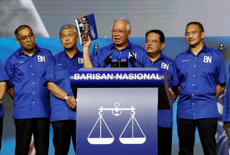 Malaysia's Prime Minister and president of ruling party National Front, Najib Razak holds up a booklet on his party's manifesto during its launch for upcoming general elections in Kuala Lumpur, Malaysia April 7, 2018. REUTERS/Lai Seng Sin