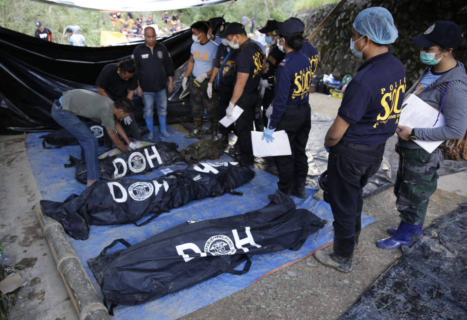 Rescatistas revisan el lunes 17 de septiembre de 2018 los cuerpos recuperados en el sitio de un deslizamiento provocado por el tifón Mangkhut en la provincia de Benguet, Filipinas. (AP Foto/Aaron Favila)