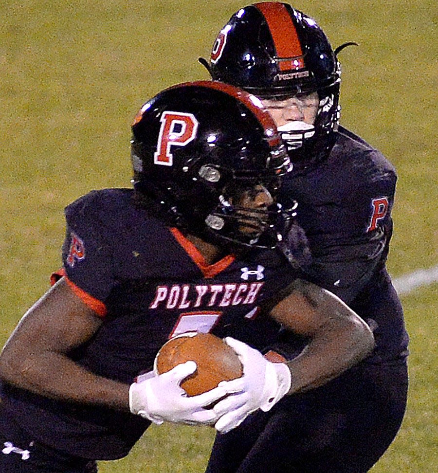 Polytech quarterback Isaac Balcerak hands to Noah Walker in the first quarter of Friday night's game with Wilmington Charter.