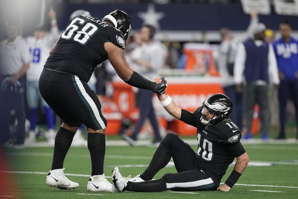 Philadelphia Eagles' Jordan Mailata helps Gardner Minshew up after throwing an incolplete pass in the final seconds of an NFL football game against the Dallas Cowboys Saturday, Dec. 24, 2022, in Arlington, Texas. (AP Photo/Tony Gutierrez)