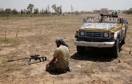 A fighter of Libyan forces allied with the U.N.-backed government prays in front of his sniper rifle during a battle with Islamic States fighters in Sirte, Libya, July 21, 2016. REUTERS/Goran Tomasevic