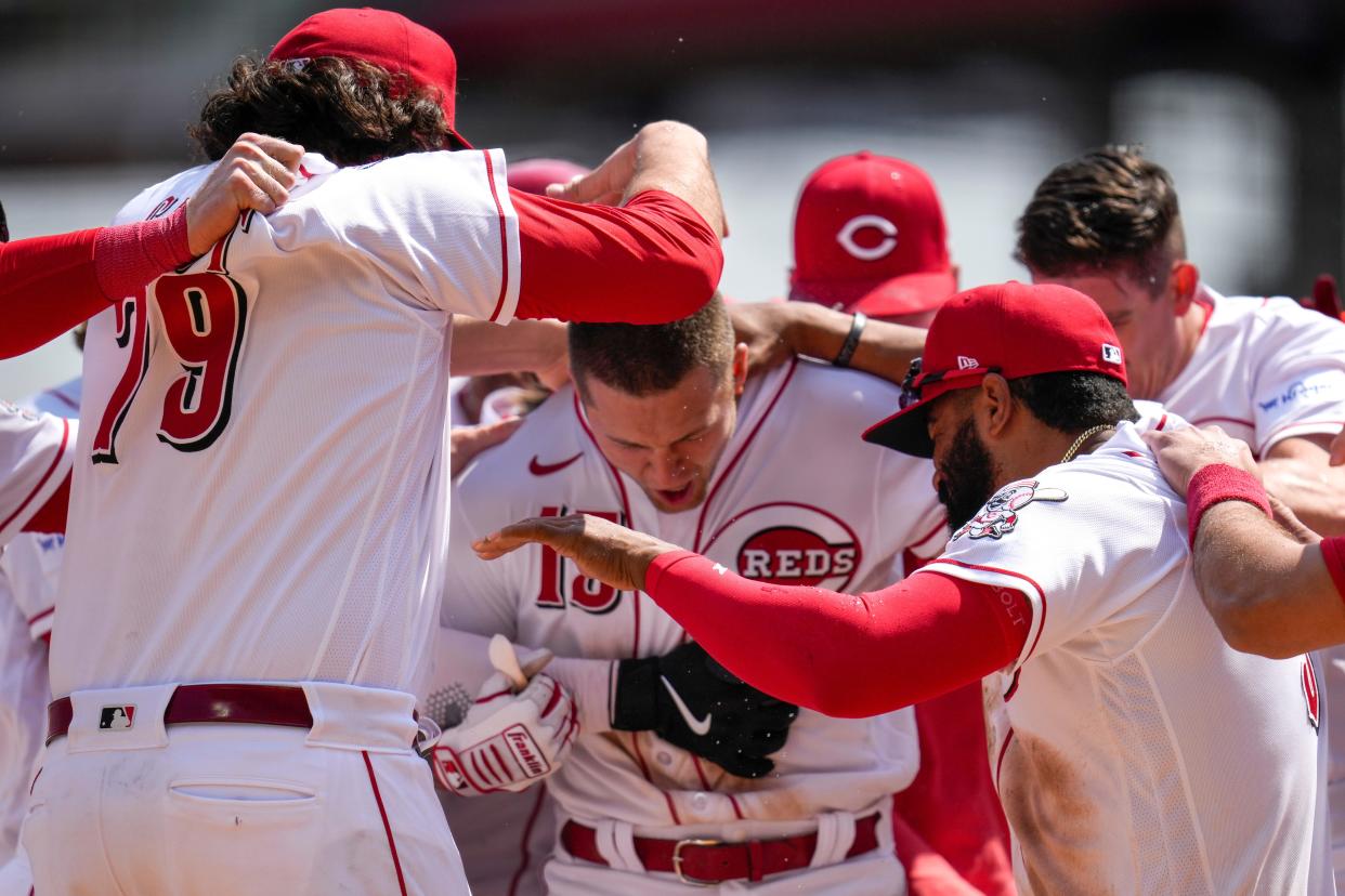 Cincinnati Reds third baseman Nick Senzel (15) is mobbed by his teammates after hitting a walk-off two-run home run-in the ninth inning of the MLB Interleague game between the Cincinnati Reds and the Texas Rangers at Great American Ball Park in downtown Cincinnati on Wednesday, April 26, 2023. The Reds won 5-3 on a walkoff two-run home run by Nick Senzel.