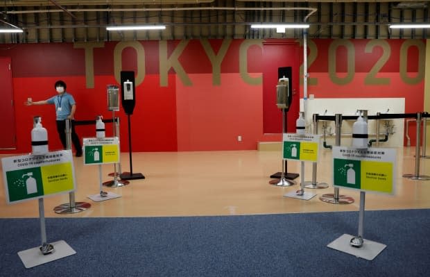 Hand sanitizers and signs for COVID-19 countermeasures are placed at the entrance of the fitness centre at the multi-function complex of the Olympic and Paralympic Village in Tokyo. (Kim Kyung-Hoon/Reuters - image credit)