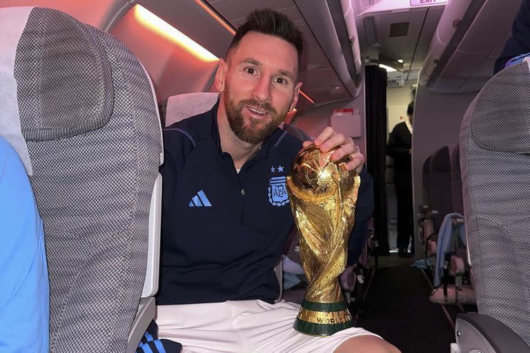 Messi en el avión de regreso a Argentina, con el trofeo