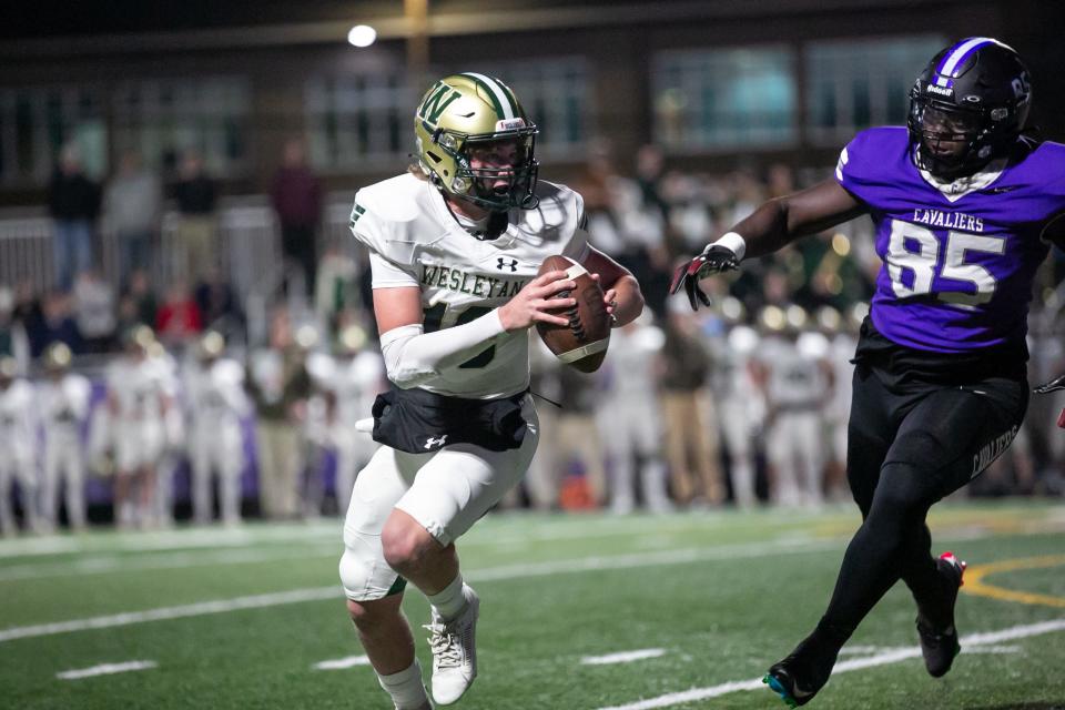 Wesleyan quarterback Ben Brown comes out of the pocket to complete the field