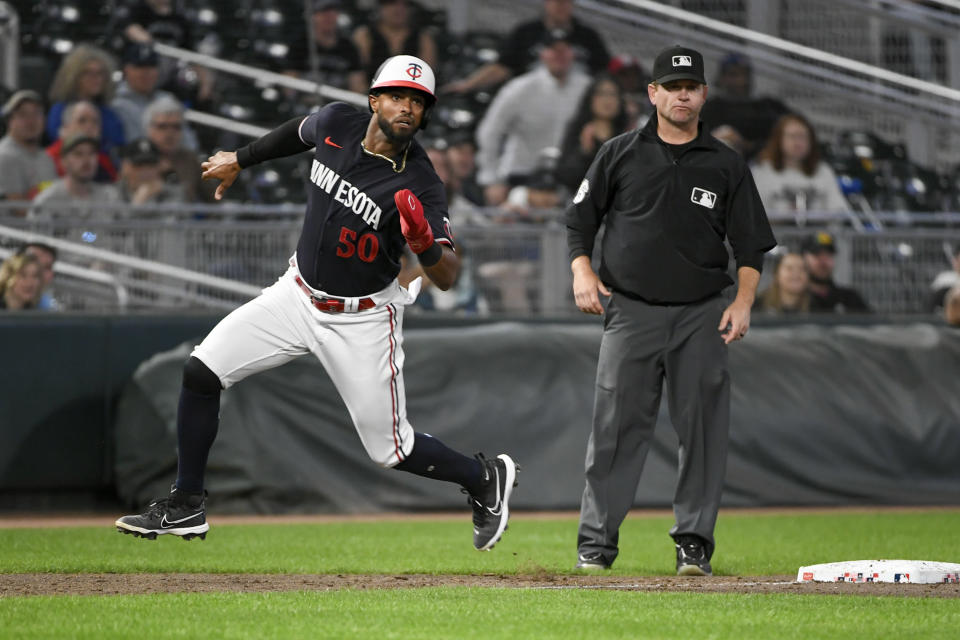 Minnesota Twins' Willi Castro rounds third base as he watches Chicago White Sox pitcher Jesse Scholtens make a throwing error to first during the 10th inning of a baseball game, Tuesday, April 11, 2023, in Minneapolis. Castro scored, giving the Twins a 4-3 victory. (AP Photo/Craig Lassig)