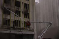 Firefighters battle a fire in Cheung Sha Wan, a residential and industrial area, in Hong Kong, Friday, March 24, 2023. (AP Photo/Louise Delmotte)