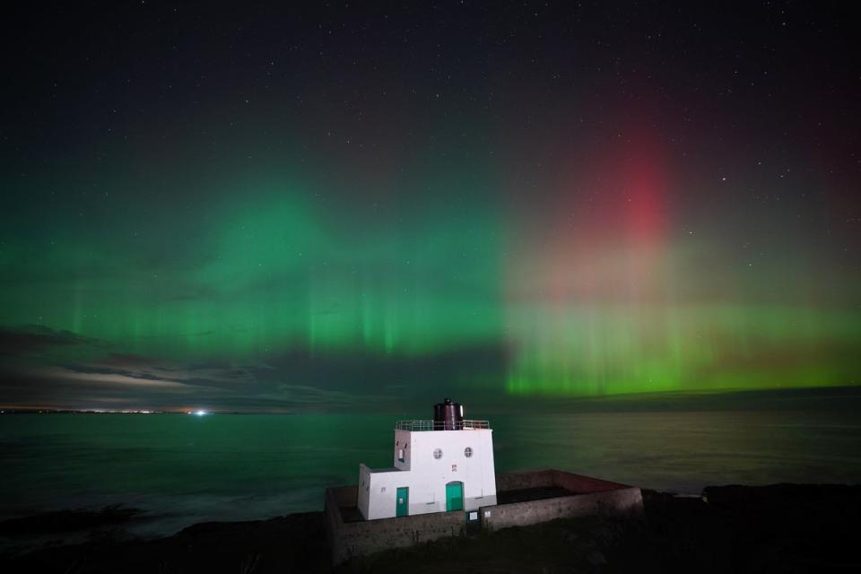 The aurora borealis, appeared over Bamburgh Lighthouse, in Northumberland, last month (Owen Humphreys/PA)