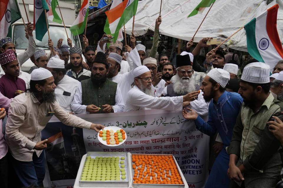 Indians distribute sweets to celebrate the success of Chandrayaan - 3 soft landing on the moon, in Mumbai, India, Wednesday, Aug. 23, 2023.(AP Photo/Rajanish Kakade)