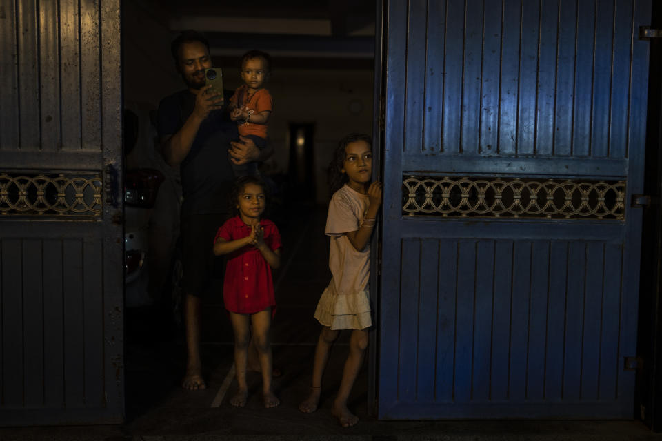 Children watch Dravida Munnetra Kazhagam party candidate Dayanidhi Maran's election roadshow pass through their residential area in the southern Indian city of Chennai, April 14, 2024. (AP Photo/Altaf Qadri)