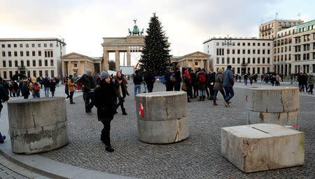 People walk beside concrete barriers at the Brandenburg Gate in Berlin, Germany December 27, 2016. REUTERS/Fabrizio Bensch/Files
