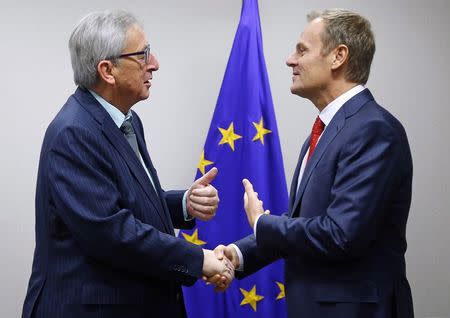 Newly nominated European Council President Donald Tusk (R) welcomes new European Commission President Jean-Claude Juncker at the EU council headquarters in Brussels in this December 1, 2014 file photo.REUTERS/Yves Herman/Files