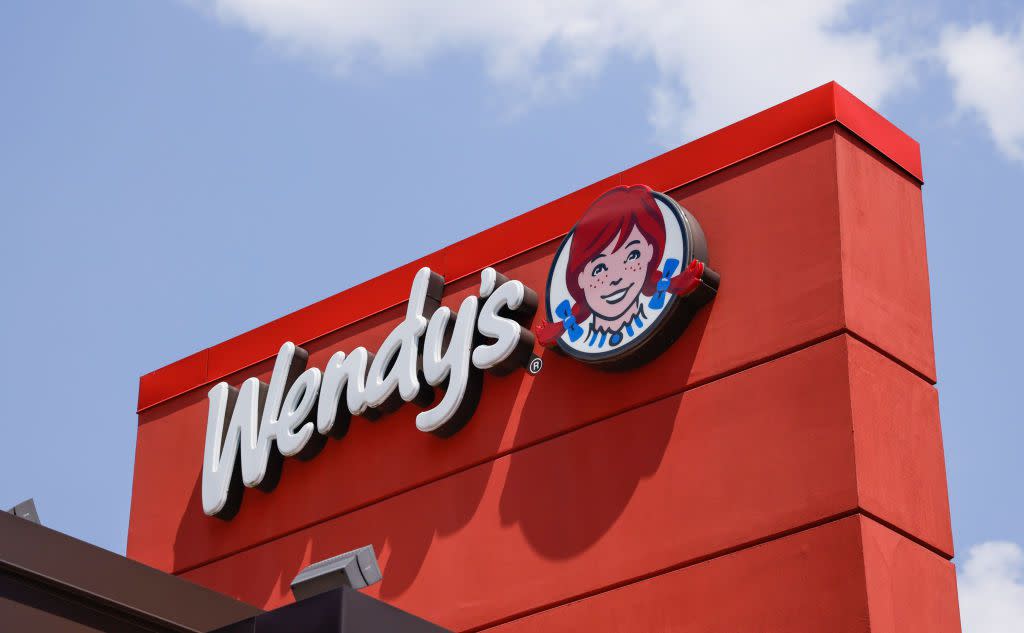 The Wendy's mascot is displayed on a sign pictured against a blue sky over a franchise in Nanuet, New York.