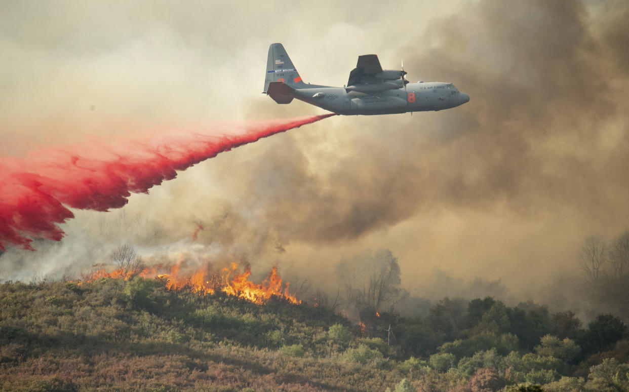 A U.S. Air Force plane drops fire retardant on a burning hillside in the Ranch Fire in Clearlake Oaks, California on Sunday, Aug. 5, 2018. (Photo: Associated Press)