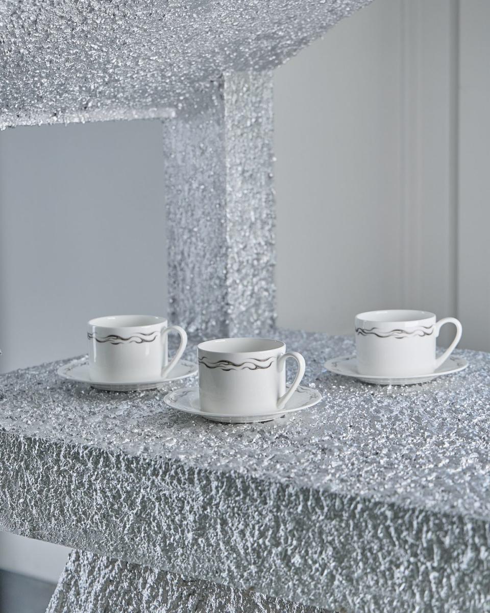 a group of white cups on a marble counter