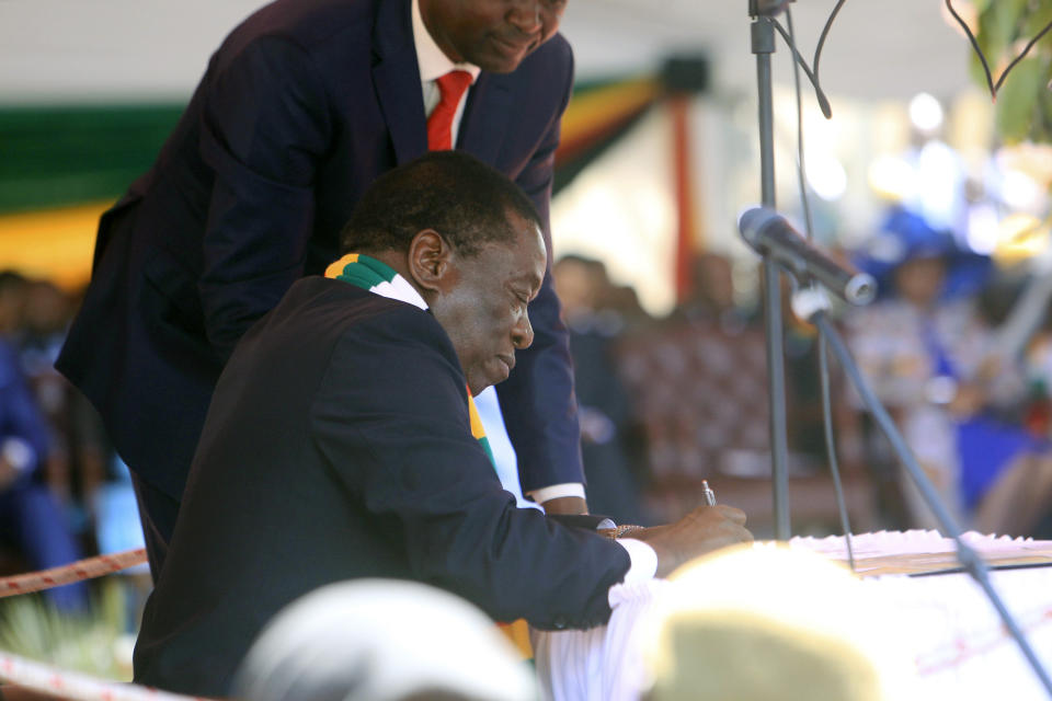 Zimbabwean President Emmerson Mnangagwa signs during his inauguration ceremony at the National Sports Stadium in Harare, Sunday, Aug. 26, 2018. The Constitutional Court upheld Mnangagwa's narrow election win Friday, saying the opposition did not provide " sufficient and credible evidence" to back vote- rigging claims. (AP Photo/Tsvangirayi Mukwazhi)