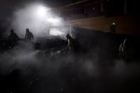 Volunteers from the Blue Sky Rescue team disinfect at the Qintai Grand Theatre in Wuhan