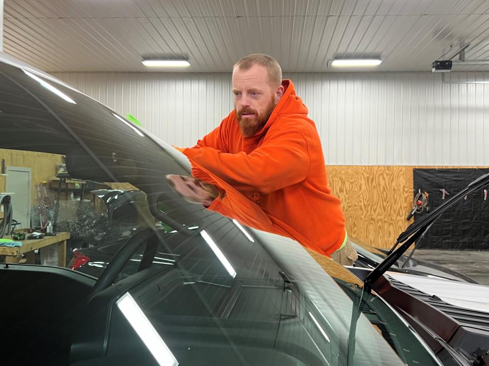 Beam Clean Auto Detailing owner Derek Beam cleans the windshield of a pickup truck recently at his 1774 Victor Road business.