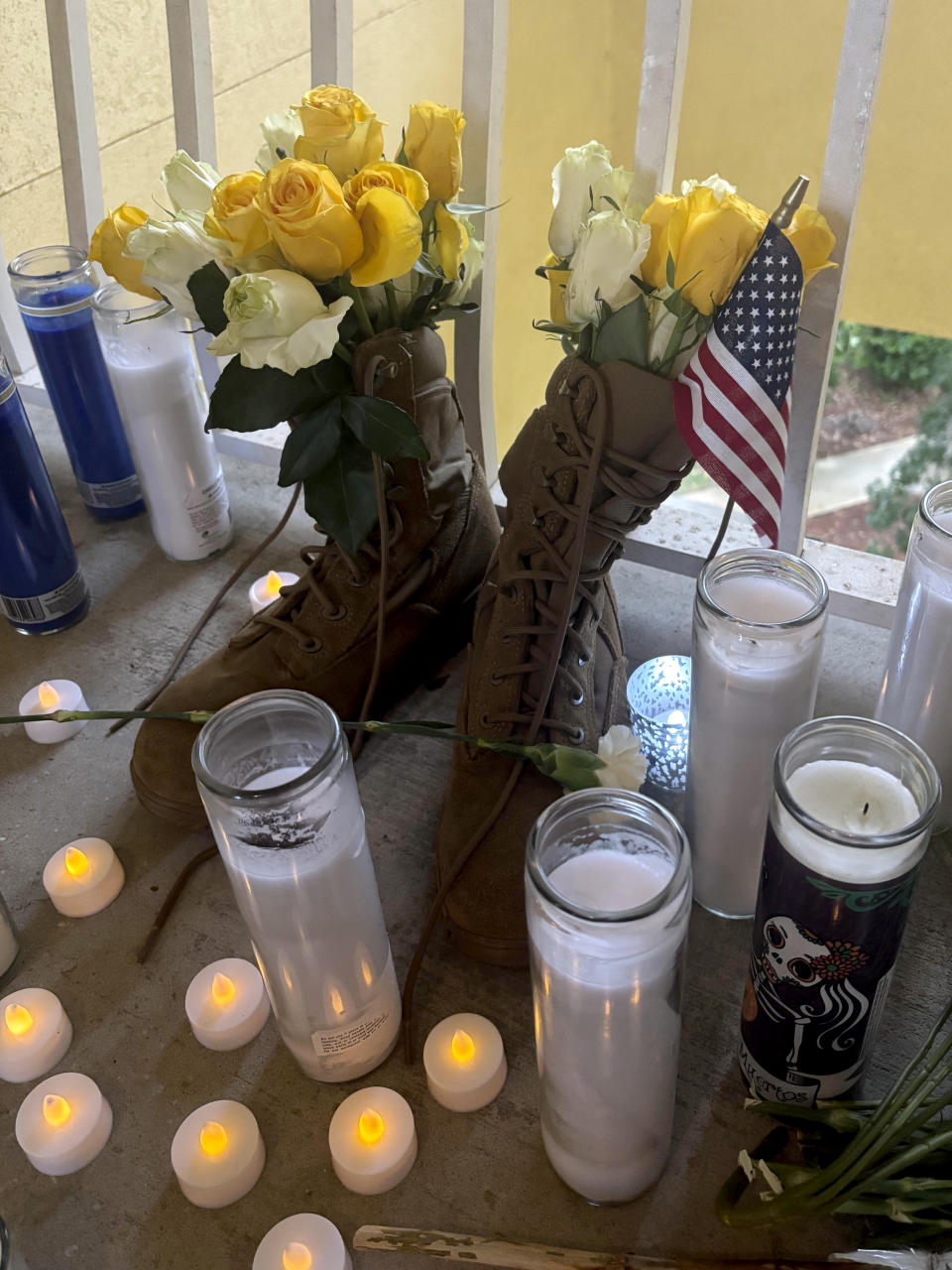 A small shrine is pictured Monday, May 13, 2024, in Fort Walton Beach, Fla. at the door of an apartment where a Florida deputy shot and killed Senior Airman Roger Fortson. The shrine includes a long wooden plank, anchored by two sets of aviator wings and a black marker to leave thoughts, a Stella Artois, and combat boots and an American Flag. As the unit takes a day to grieve and prepare for a funeral Friday, May 17, questions remain about the shooting. (AP Photo)