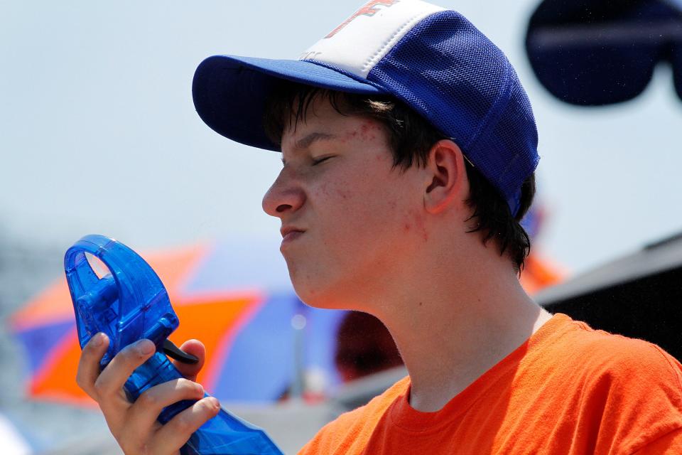 Tim Boehlein, 14, uses a mist fan to try and stay cool during the 2011 NCAA Softball Tournament Regional round at Katie Seashole Pressly Stadium, in Gainesville, May 22, 2011. Temperatures were in the 90's during the game.