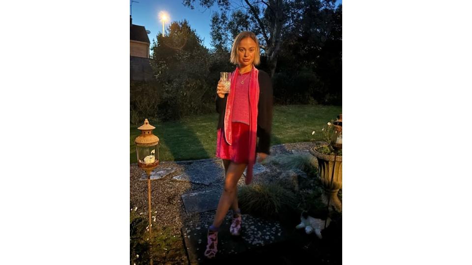 Amelia Windsor in a pink velvet mini dress holding a drink