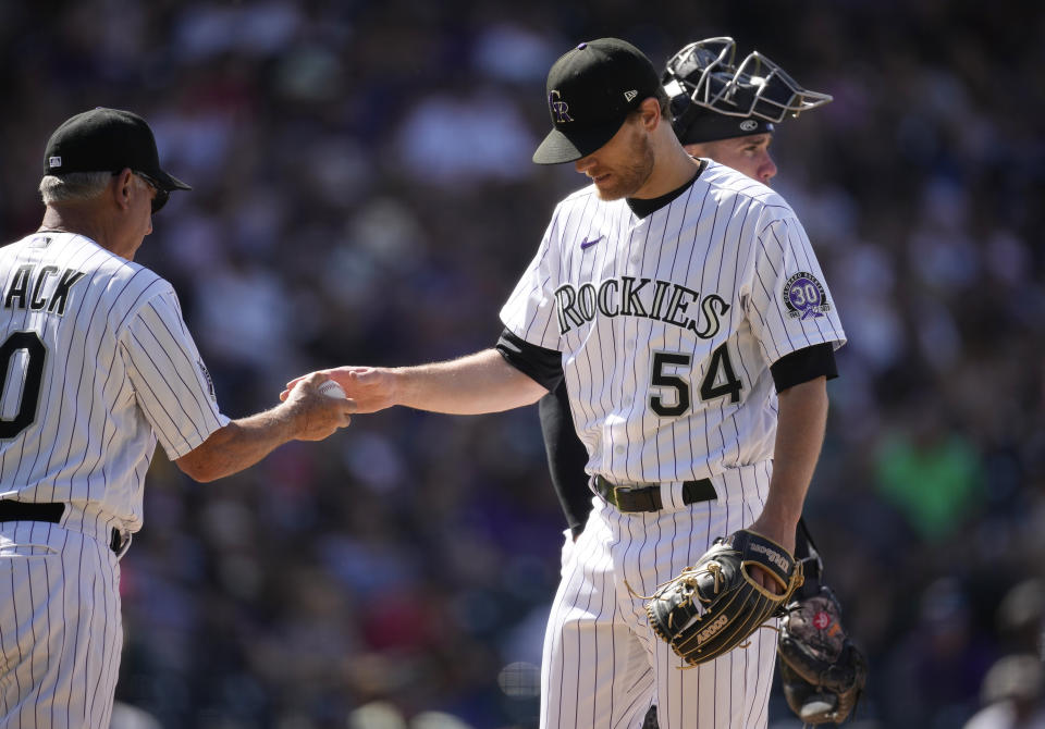 Colorado Rockies manager Bud Black, left, takes the ball from relief pitcher Matt Koch who is pulled from the mound after giving up a double to Chicago White Sox's Yoan Moncada to allow in two runs in the eighth inning of a baseball game Sunday, Aug. 20, 2023, in Denver. (AP Photo/David Zalubowski)