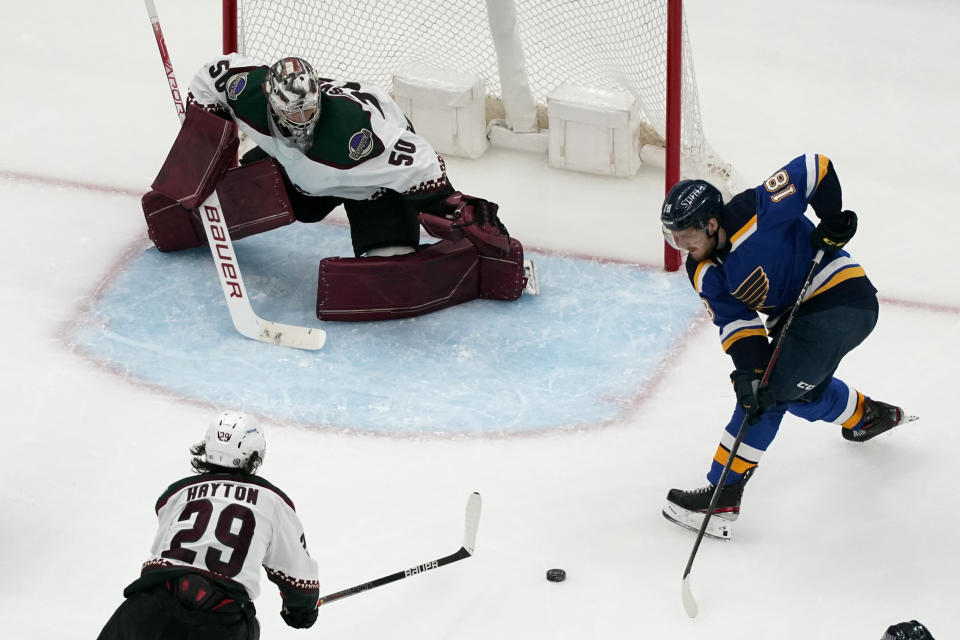 St. Louis Blues' Robert Thomas (18) tries to get off a shot as Arizona Coyotes goaltender Ivan Prosvetov (50) and Barrett Hayton (29) defend during the third period of an NHL hockey game Monday, April 4, 2022, in St. Louis. (AP Photo/Jeff Roberson)